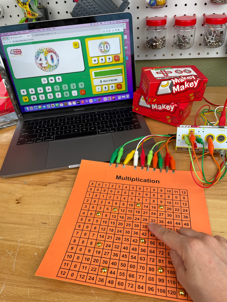 Multiplication table wired to a Makey Makey next to a laptop