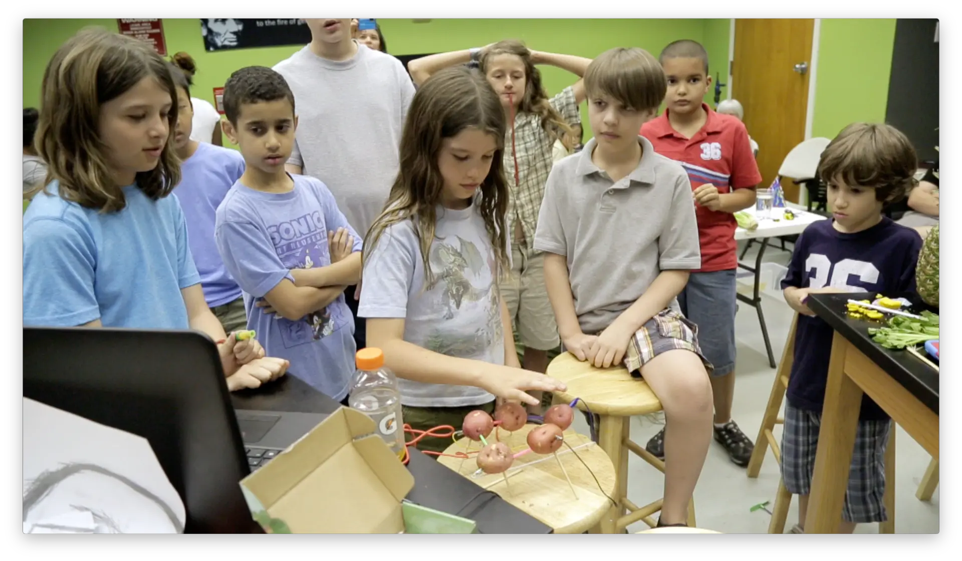 Student building with clay and a Makey Makey alongside a mentor and teacher