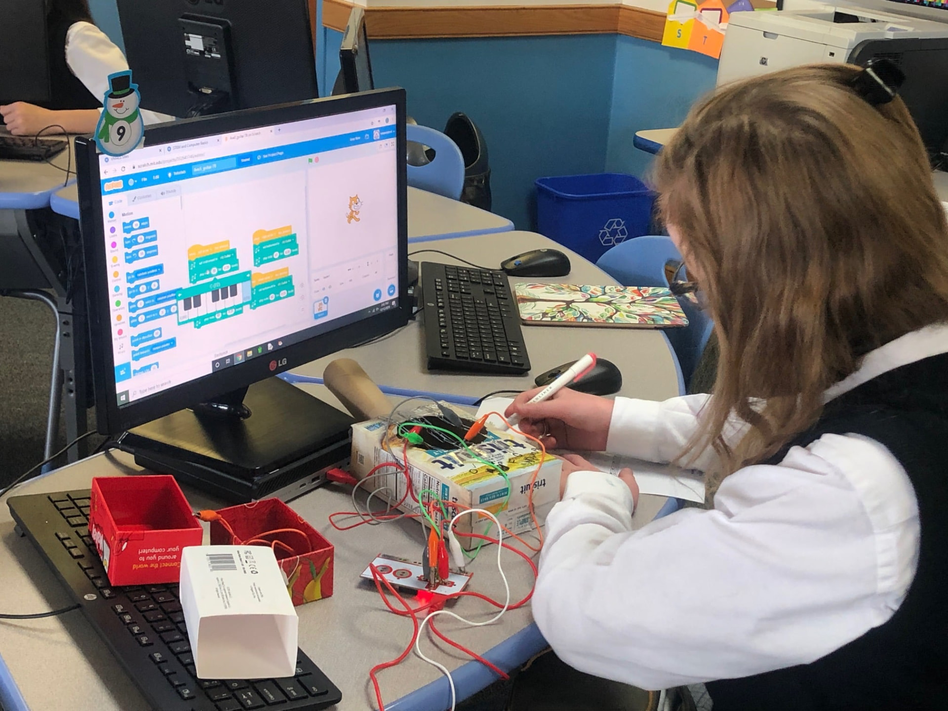 Student coding with Makey Makey and Scratch in a classroom