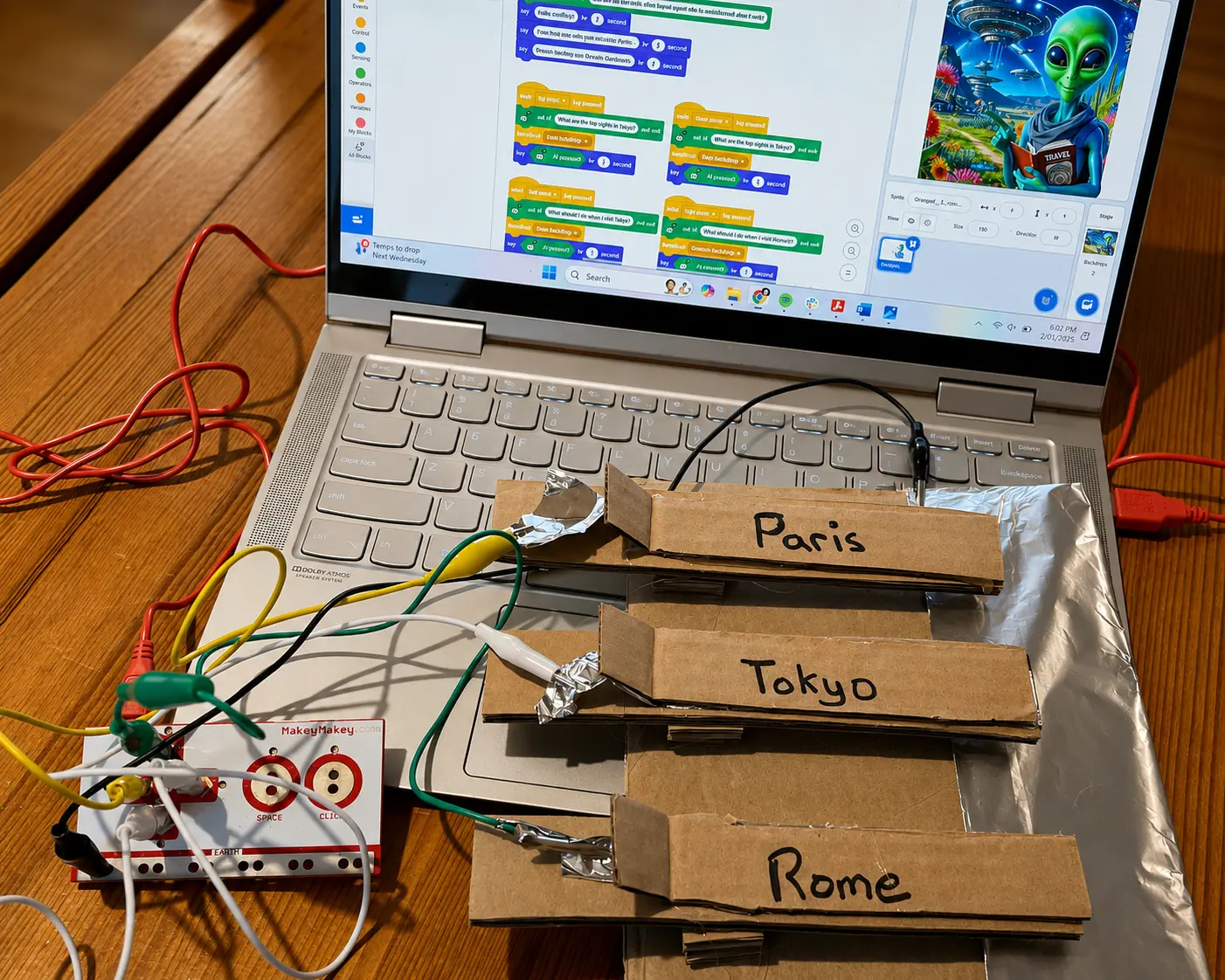 Cardboard keys labeled Paris, Tokyo and Rome taped with foil and wired to a Makey Makey and a laptop running Scratch
